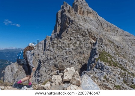Young woman with long hair walking in a wonderful dolomitic scenery. Mount Latemar, Trentino, Italy. Traveling photography and outdoor sport activity concept