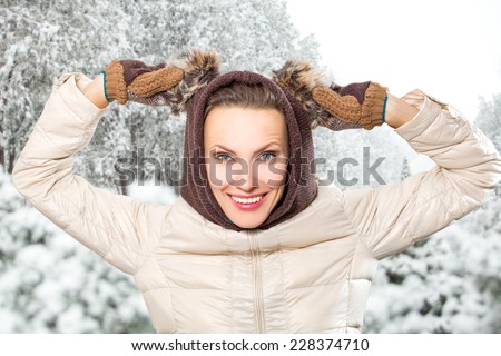 Attractive young woman in wintertime outdoor. Funny winter woman