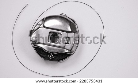 Bobbin case with black bobbin and thread coming out Royalty-Free Stock Photo #2283753431