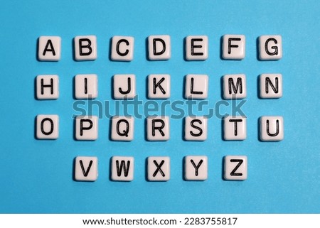 English alphabet. Beads white tiles on a blue background. Royalty-Free Stock Photo #2283755817