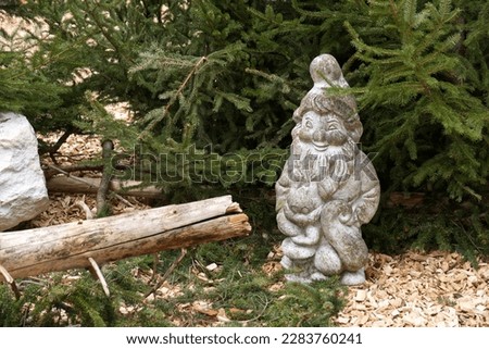 A stone gnome as garden decoration. High quality photo