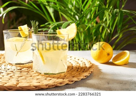 Summer refreshing drinks with fresh lemon slices and rosemary sprigs. Alcoholic cocktails with citrus fruits. cold lemon water Royalty-Free Stock Photo #2283766321
