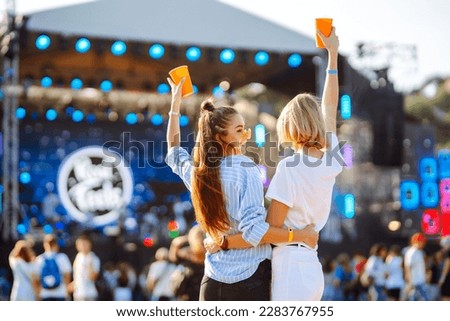 Two young woman  with beer at music festival. Beach party, summer holiday. Royalty-Free Stock Photo #2283767955