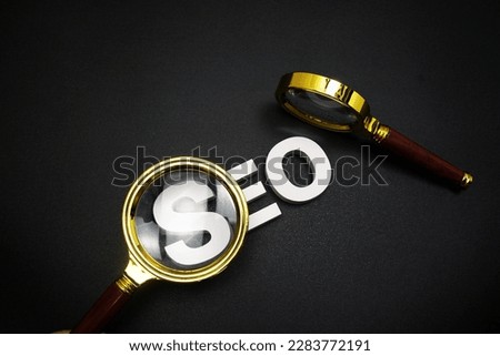 SEO (search engine optimization) text message with magnifying glass on black background
