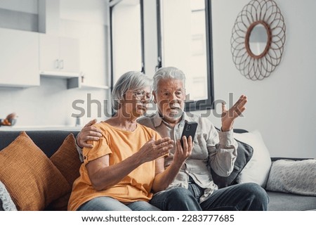 Shocked upset elderly couple getting bad news, finding fraud, money stealing, loss, overspending, financial problem, holding calculator, using phone, staring at monitor Royalty-Free Stock Photo #2283777685