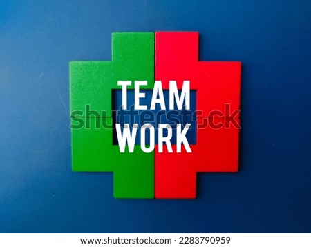 Colored wooden puzzle with the word TEAM WORK on blue background. Business concept.