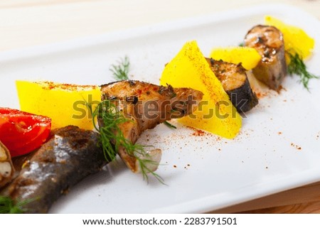 Picture of deliciously baked rainbow trout steaks with potatoes on white plate