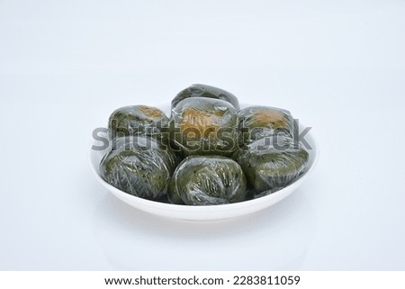 A plate of Qingtuan stuffed with egg yolk and dried meat floss isolated on white background. Traditional seasonal Chinese delicacies in Jiangnan area around the time of Tomb Sweeping Day.  Royalty-Free Stock Photo #2283811059