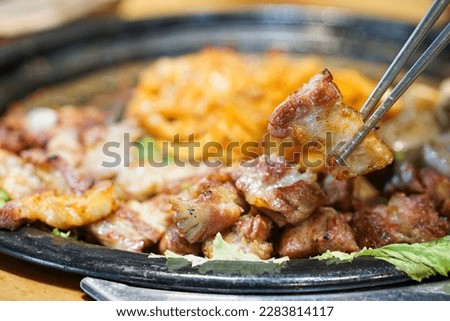 Samgyeopsal Gui - Grilled pork belly over hot charcoal stove, Korean BBQ style, The national street food of Korea, Selective Focus. Royalty-Free Stock Photo #2283814117