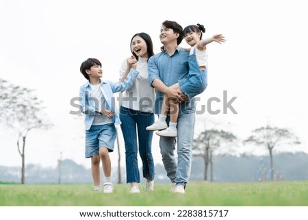 Asian family photo walking together in the park Royalty-Free Stock Photo #2283815717