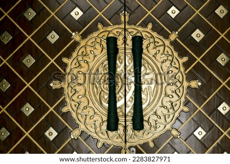 black doorknob with pattern, and brown background with Islamic pattern