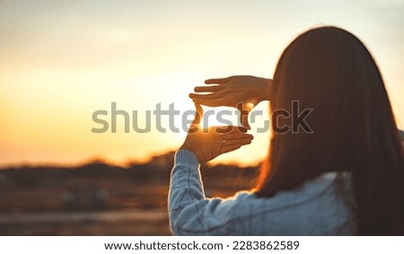Woman hands making frame gesture with sunset, Female capturing the sunrise. Business planning, strategy and vision concept. Royalty-Free Stock Photo #2283862589