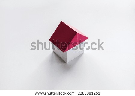 White and red paper house origami isolated on a blank background.