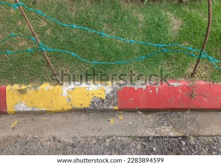 Red and yellow concrete sidewalk signs on a road. Footpath road