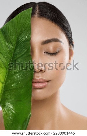 Skin Care. Natural Beauty Woman. Model with Fresh Clean Skin Make up and Full Lips with Big Green Tropic Leaf. Eco Cosmetics and Spa Cosmetology. Asian Girl Close up Portrait with Closed Eyes Royalty-Free Stock Photo #2283901445