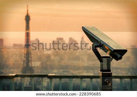 A coin operated binocular with a background of Defocused Eiffel tower view in Paris.