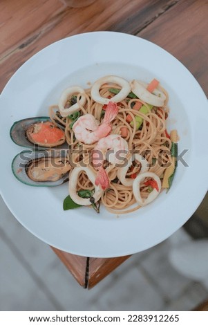 Spaghetti with Spicy Mixed Seafood: This top view picture features a mouth-watering plate of spaghetti tossed with a spicy and flavorful mix of seafood.