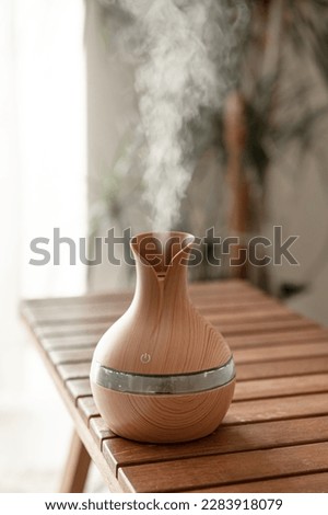 Aroma oil diffuser lamp on a blurred background. Royalty-Free Stock Photo #2283918079