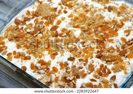 Konafa topped with whipped cream, raisins, nuts, shredded coconut and stuffed with cream and fresh mango layer and soaked with honey sugar syrup, Eastern Turkish and Egyptian kunafa with manga