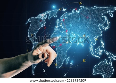 Close up of hand pointing at glowing digital map with ariplane connections on dark background. Flight routes airplanes network and global transportation interface