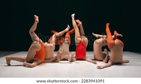 Legs up. Group of young girls, experimantal dancers performing on stage in bodysuits. Creative and artistic dancers. Concept of art, movement, youth, fashion, lifestyle, flexibility, inspiration Royalty-Free Stock Photo #2283941091