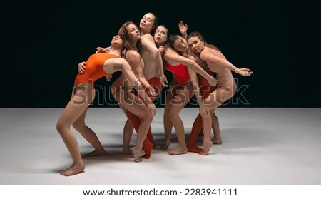 Flexible aesthetic movements, experimental dance. Group of young beautiful girls performing over black studio background. Concept of art, movement, youth, fashion, artistic lifestyle Royalty-Free Stock Photo #2283941111