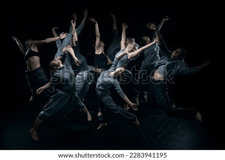 Top view. Expressive contemp dance. Group of young people dancing against black studio background. Concept of modern freestyle dance, contemporary art, movements, hobby and creative lifestyle Royalty-Free Stock Photo #2283941195