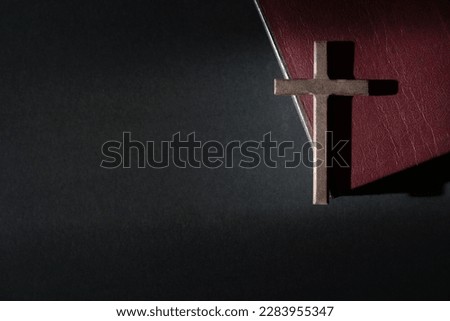 Wooden crucifix cross on a leather cover bible. Top view, copy space.