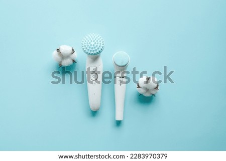 Face cleansing brush isolated on blue background.