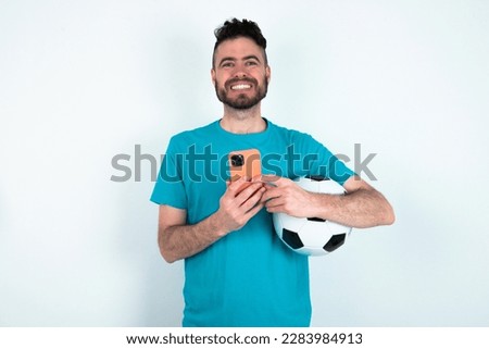 young handsome man wearing blue T-shirt over white background Mock up copy space. Using mobile phone, typing sms message