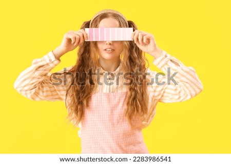 Female artist with paint color palette on yellow background