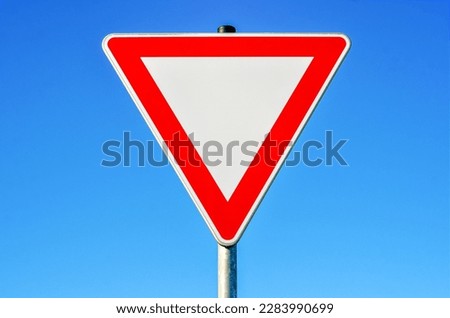 Yield sign against blue sky, closeup
