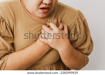 Obese women have obesity, dangerous conditions, risk many diseases have sudden heart attack. And she felt pain in her chest. Help yourself cover your chest with your hands to relieve the pain. Royalty-Free Stock Photo #2283990929