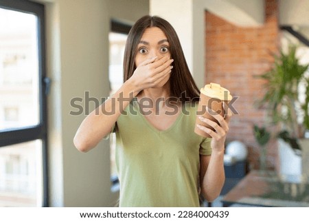 covering mouth with a hand and shocked or surprised expression. take away coffee concept