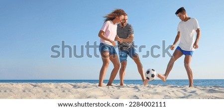 Group of friends playing football on sandy beach, space for text. Banner design