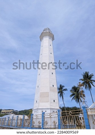 The lighthouse of the island of Rote ndao in southern Indonesia, against a blue sky in the background