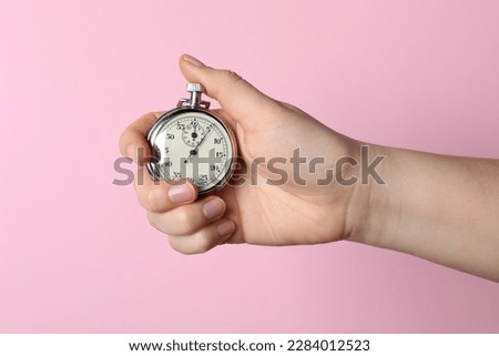 Woman holding vintage timer on pink background, closeup Royalty-Free Stock Photo #2284012523