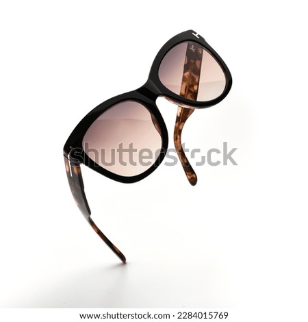 Sunglasses in flying isolated on white and grey background. Sunglasses summer woman fashion accessories as design element for promo or advertising banner. Glasses black leopard color with vintage Royalty-Free Stock Photo #2284015769