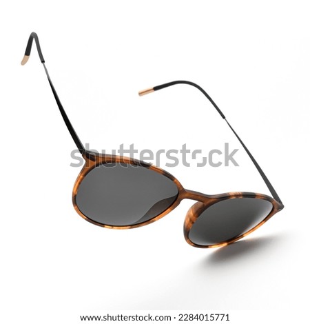 Sunglasses in flying isolated on white and grey background. Sunglasses summer woman fashion accessories as design element for promo or advertising banner. Glasses black leopard color with vintage Royalty-Free Stock Photo #2284015771