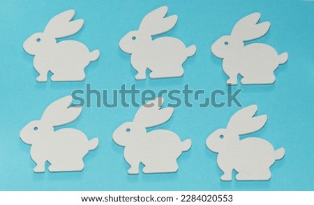 white multi-colored easter festive rabbits hares on a blue background symbol religious holiday postcard congratulation presentation easter bunny
