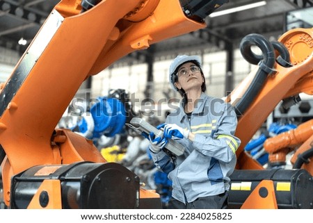 Female industrial engineer maintenance mechanic orange robot frame then assembly to robotic automation machine. Industry 4.0 is robotization technology or smart digital automation in modern factory.