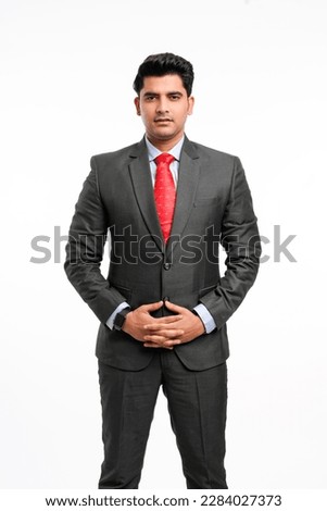 Young indian businessman in classic suit giving expression on white background.