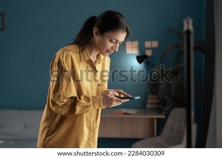 Photographer blogging concept. Woman holding phone and taking photo in home studio. Space for text