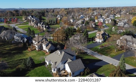 Cluster of two-story suburban houses in low density housing neighborhood with downtown Rochester building in distance background, Upstate New York, USA. Aerial view large homes with grassy yards Royalty-Free Stock Photo #2284031287