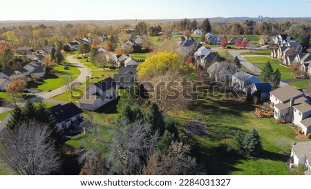 Cluster of two-story suburban houses in low density housing neighborhood with downtown Rochester building in distance background, Upstate New York, USA. Aerial view large homes with grassy yards Royalty-Free Stock Photo #2284031327