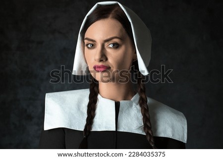 Gothic woman with pigtails in a medieval collar and cap a dark background