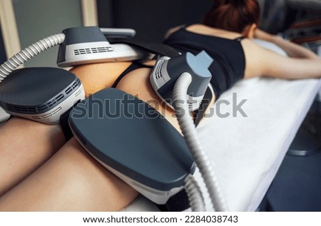 Woman getting treatment on buttocks to burn fat, build muscles and remove cellulite. Professional beauty salon Royalty-Free Stock Photo #2284038743