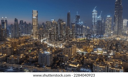 Close up view to Dubai's business bay towers aerial day to night transition . Rooftop view of some skyscrapers and new towers under construction after sunset