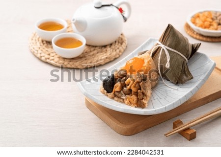 Zongzi, rice dumpling for Chinese traditional Dragon Boat Festival (Duanwu Festival) on wooden table background with ingredient.