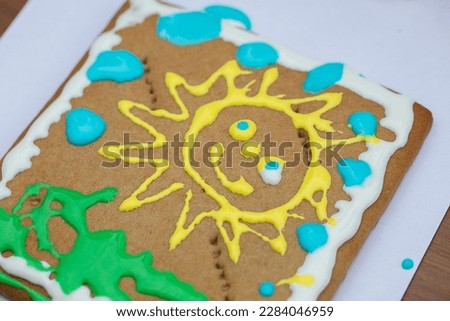 The sun is drawn with cream on a gingerbread.